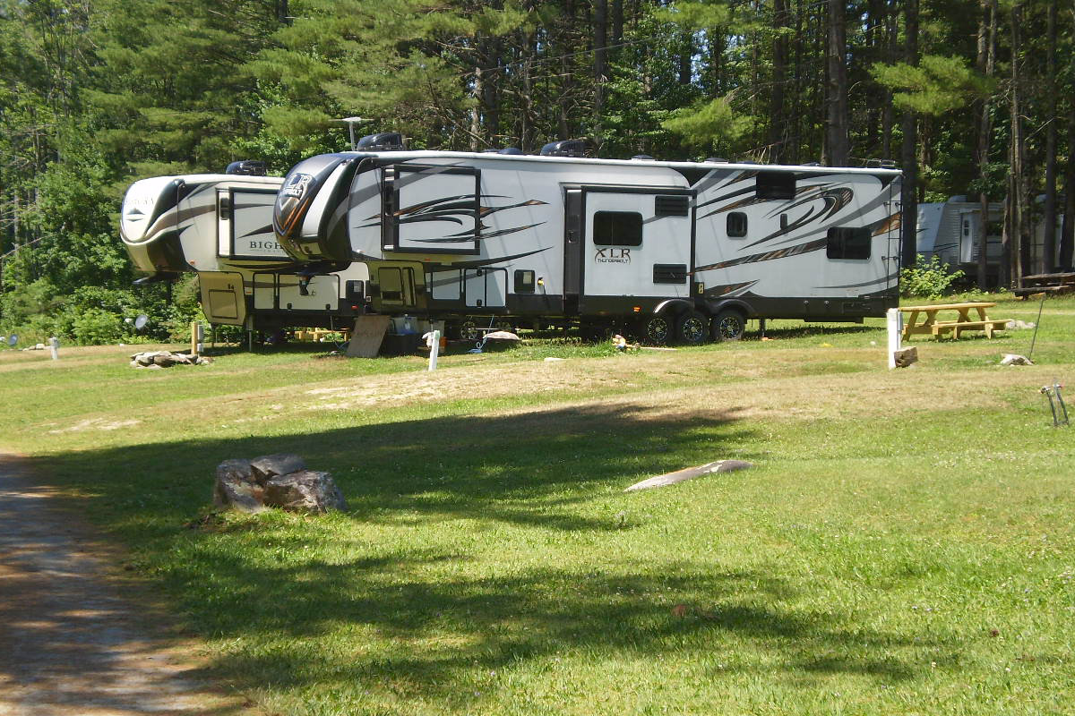 Two RVs in sunny campsites